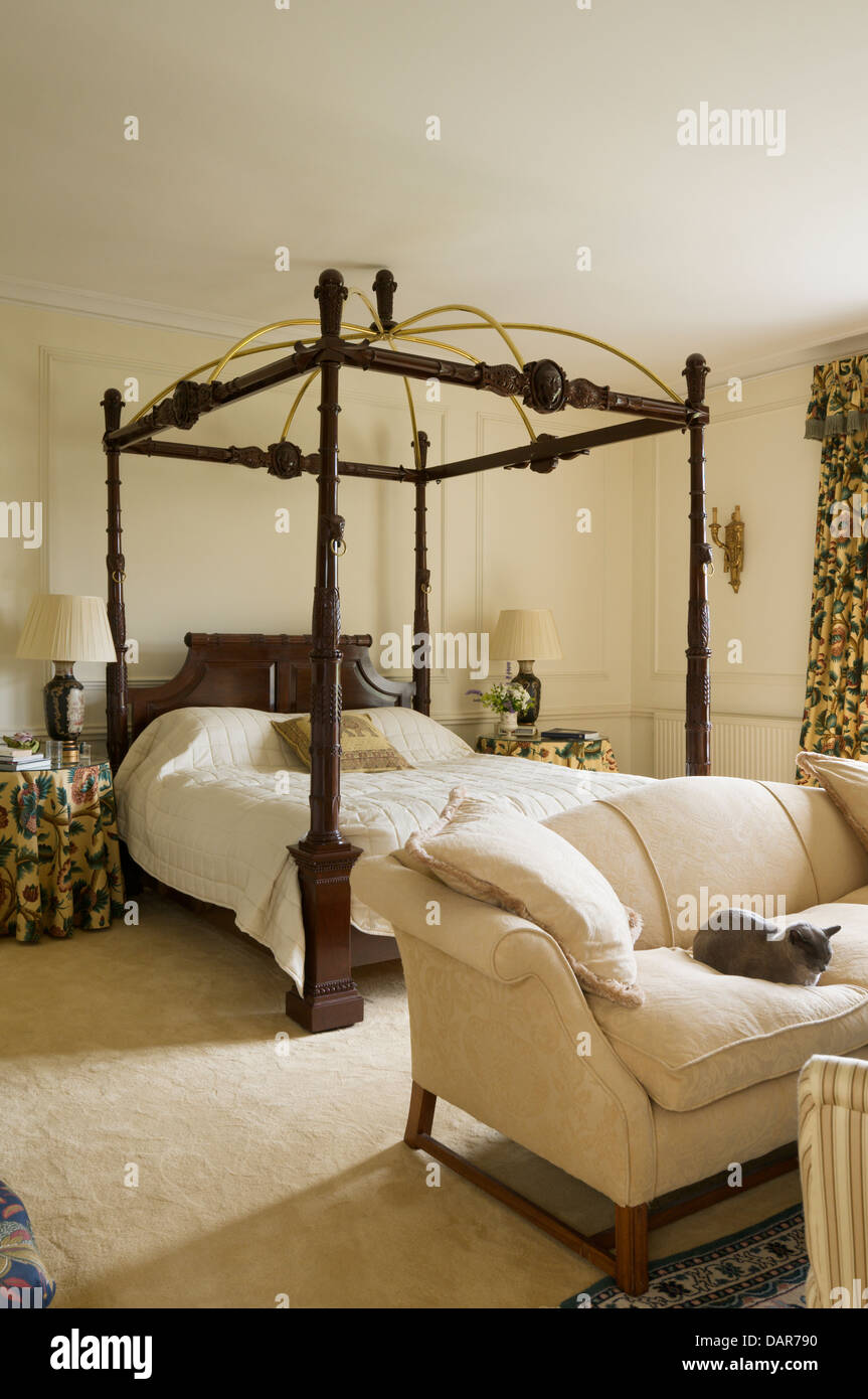 Fourposter letto in camera da letto con full-length tende a motivi geometrici e divano in Ampney Park, xvii secolo English country house Foto Stock