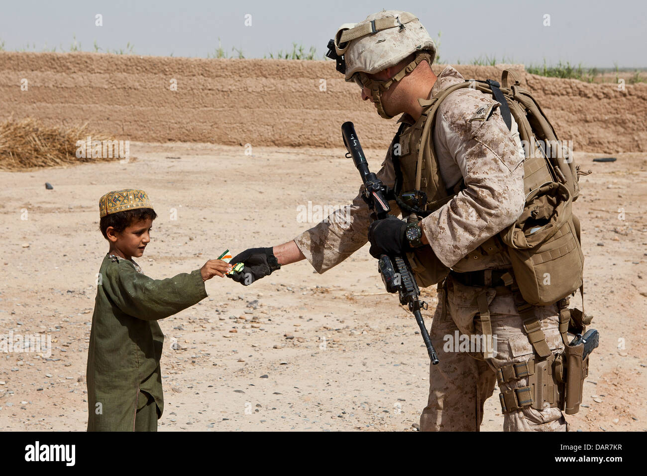 Un marine statunitense dà un giovane ragazzo candy durante un cordone e ricerca la missione Giugno 27, 2013 in Habib Abad, provincia di Helmand, Afghanistan. Foto Stock