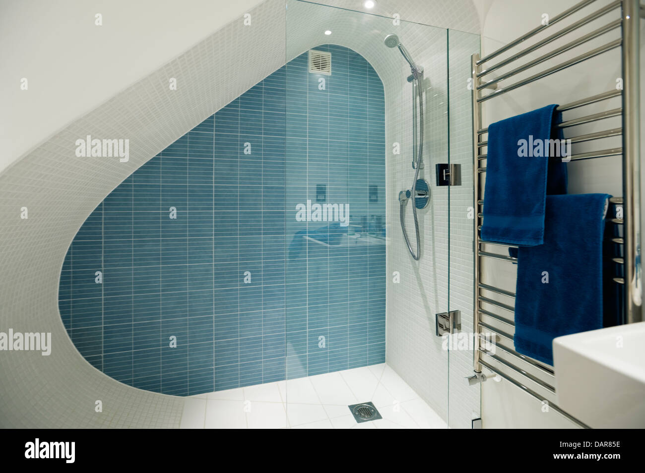 Sotto-scale seminterrato doccia piastrellata con linee pulite, doccia in vetro schermo da Aston Matthews Foto Stock