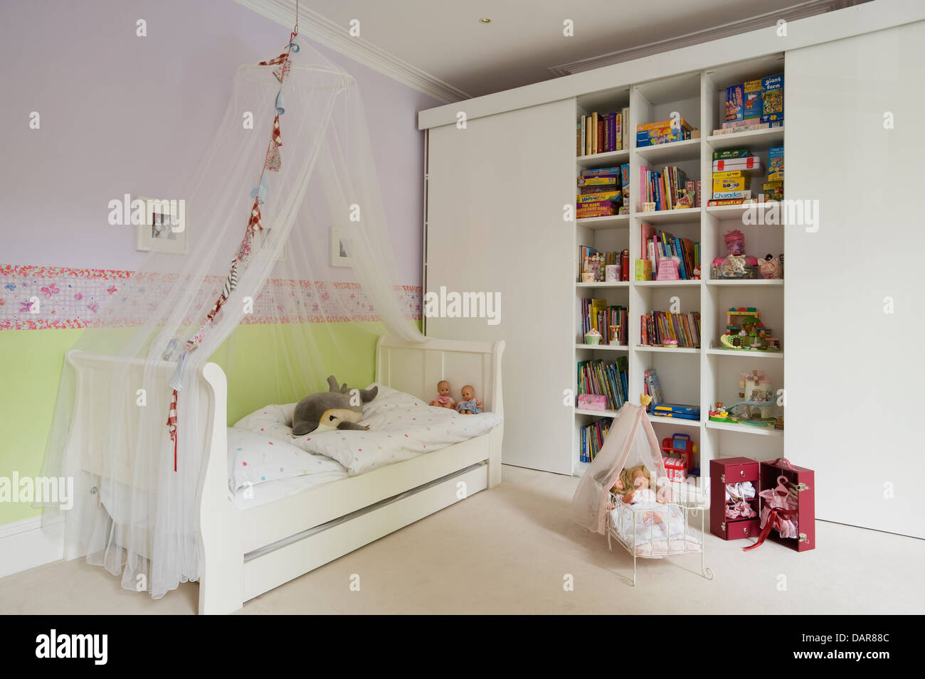 Ragazze camere da letto decorate in delicate sfumature con una farfalla confine dal designer Guild Foto Stock