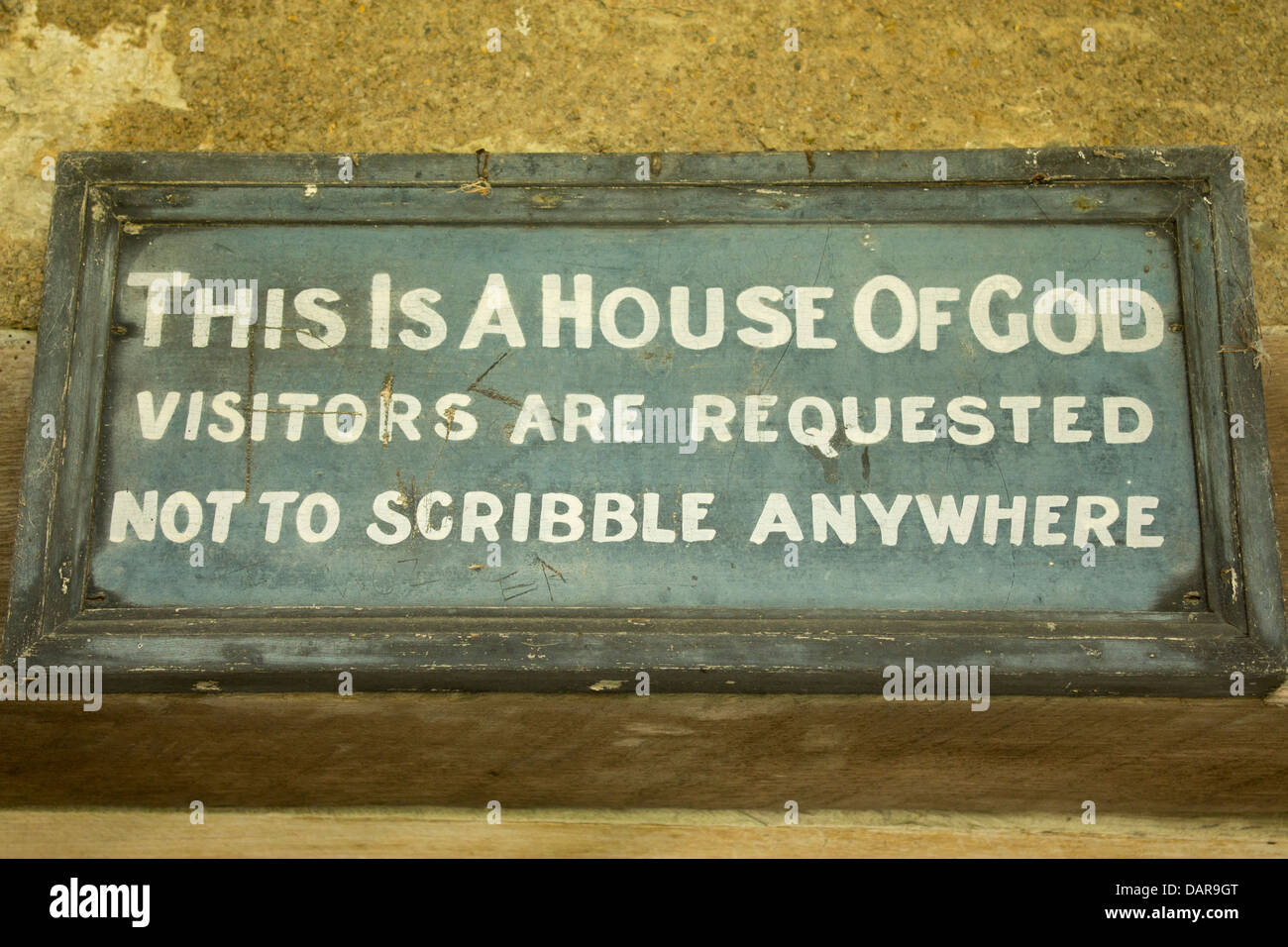 Segno sopra la chiesa porta a leggere 'Questa è una casa di Dio i visitatori sono invitati a non scarabocchiare ovunque' Llangelynnin Wales UK Foto Stock