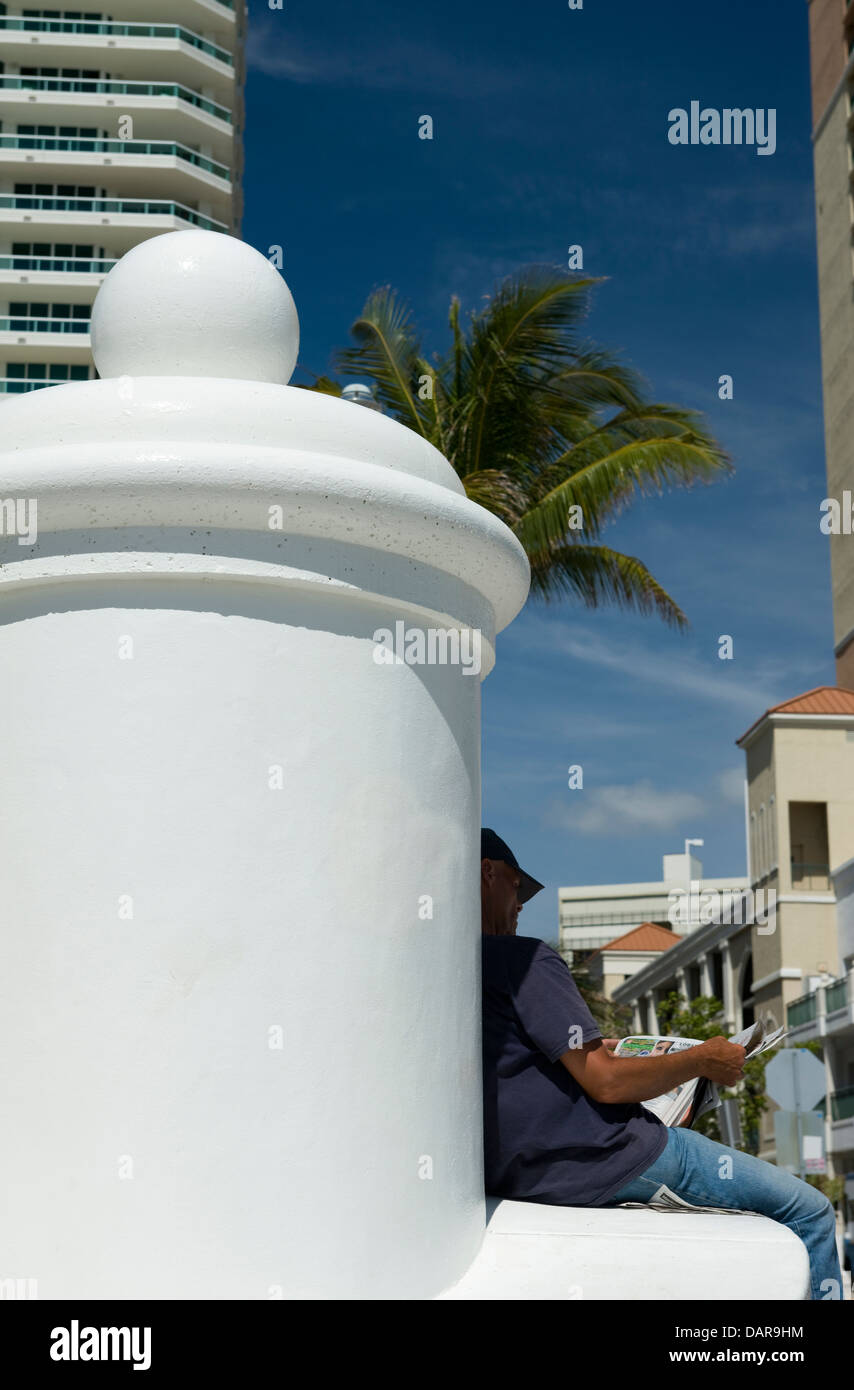 Uomo Rilassati leggendo il giornale IN OMBRA SEABREEZE BOULEVARD FORT LAUDERDALE SKYLINE FLORIDA USA Foto Stock