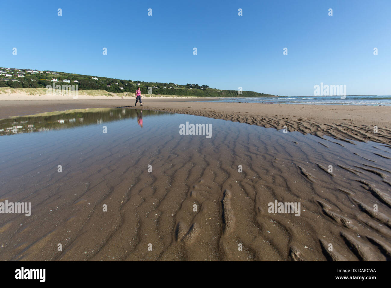 Città di Harlech, Galles. Vista pittoresca su una solitaria lady walker per la sezione meridionale della spiaggia di Harlech. Foto Stock