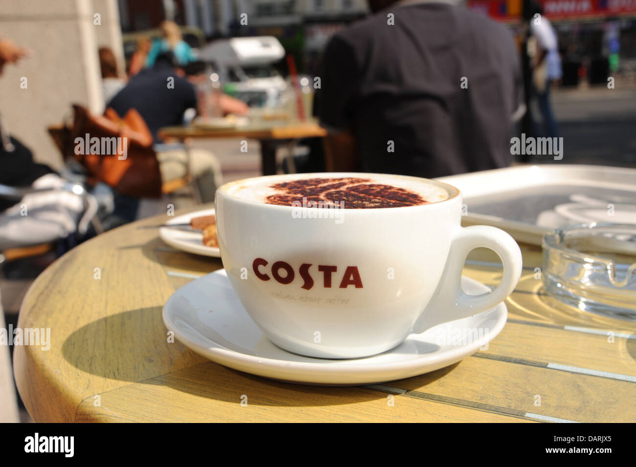 Cappuccino tazza di caffè sul tavolo al di fuori Costa Coffee cafe BRIGHTON REGNO UNITO Foto Stock