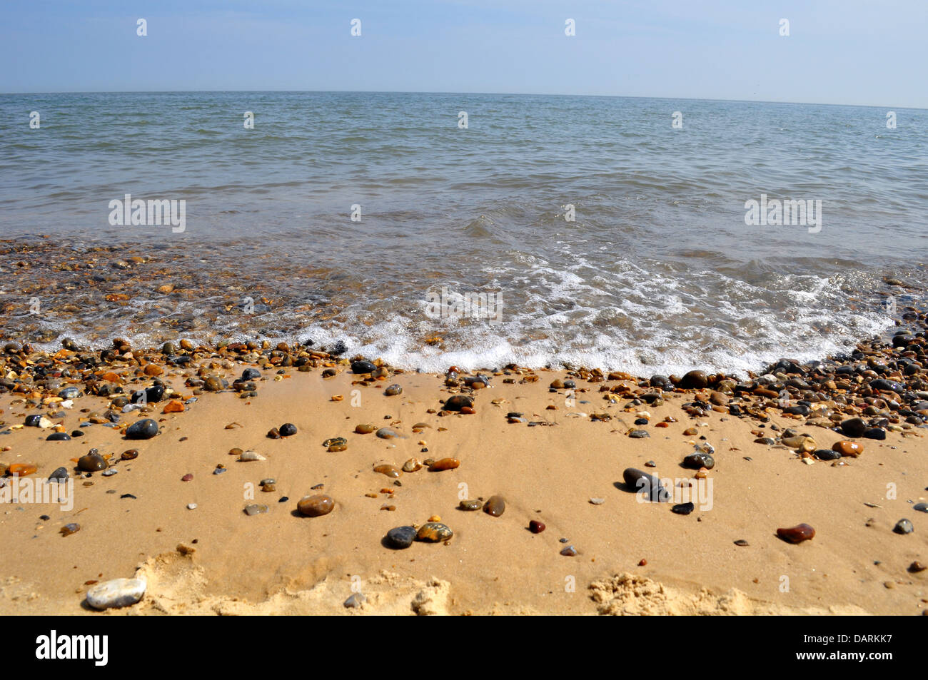 Mare, sabbia e ciottoli sulla spiaggia Foto Stock