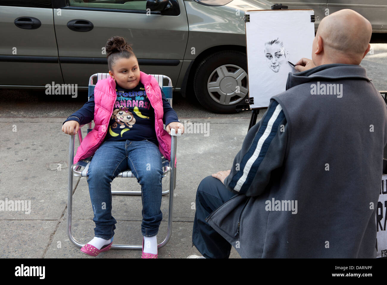 Artista di strada di disegno di un ritratto di un bambino in East Harlem, NYC Foto Stock