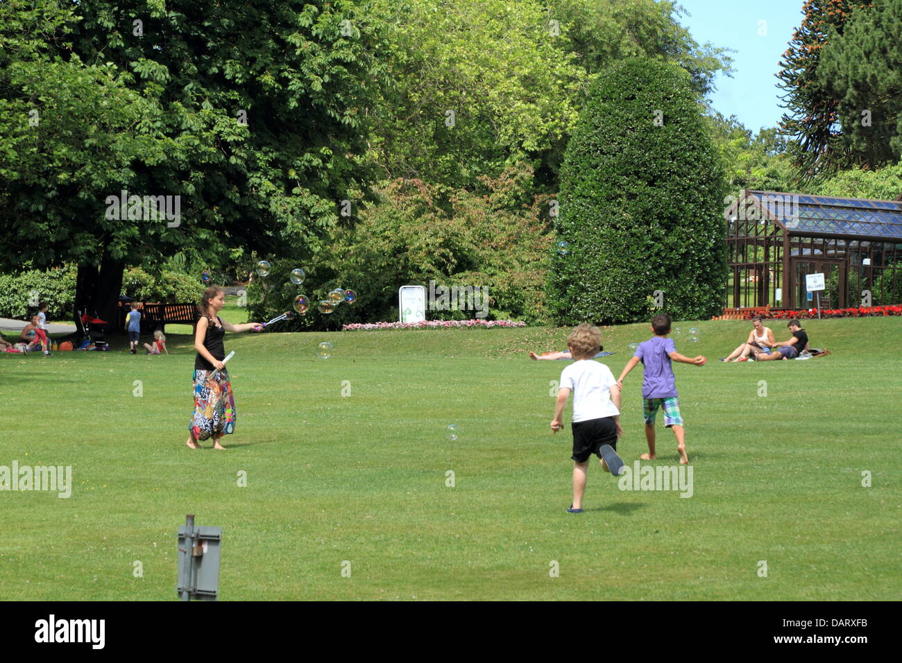 Botanic Gardens, Glasgow, Scotland, Regno Unito. Il 18 luglio 2013. Le persone che si godono la continua grande meteo in vari modi. Paul Stewart / Alamy News Foto Stock