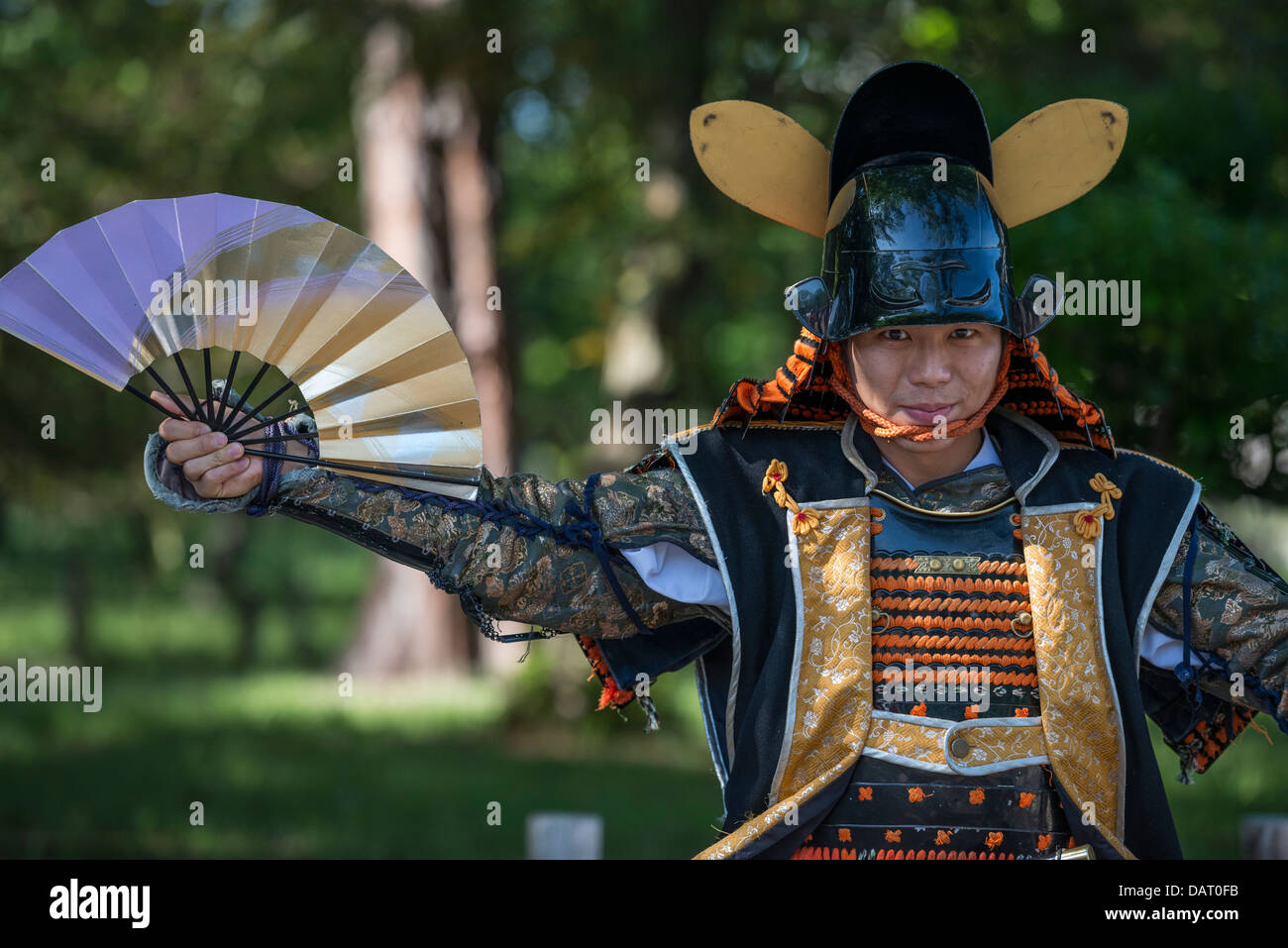 Un attore in Samurai Armor tenendo Un giapponese ventola di guerra, i Giardini del Castello di Nagoya, Nagoya, Giappone Foto Stock