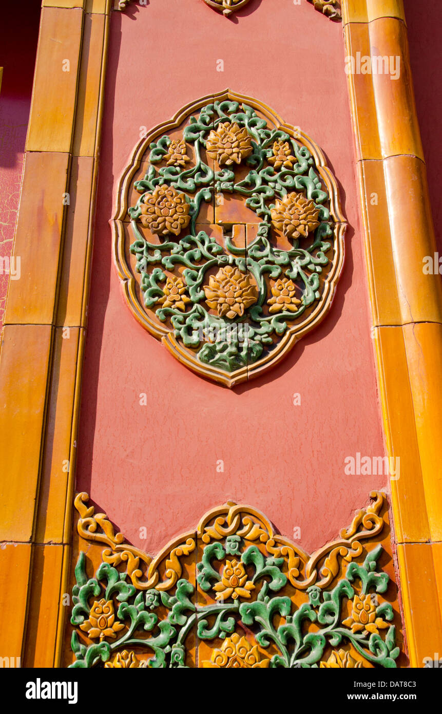 Cina, Pechino, Città Proibita (aka Zijin Cheng). Parete architettonica dettaglio mostrante tradizionale arte ceramica con design floreale. Foto Stock