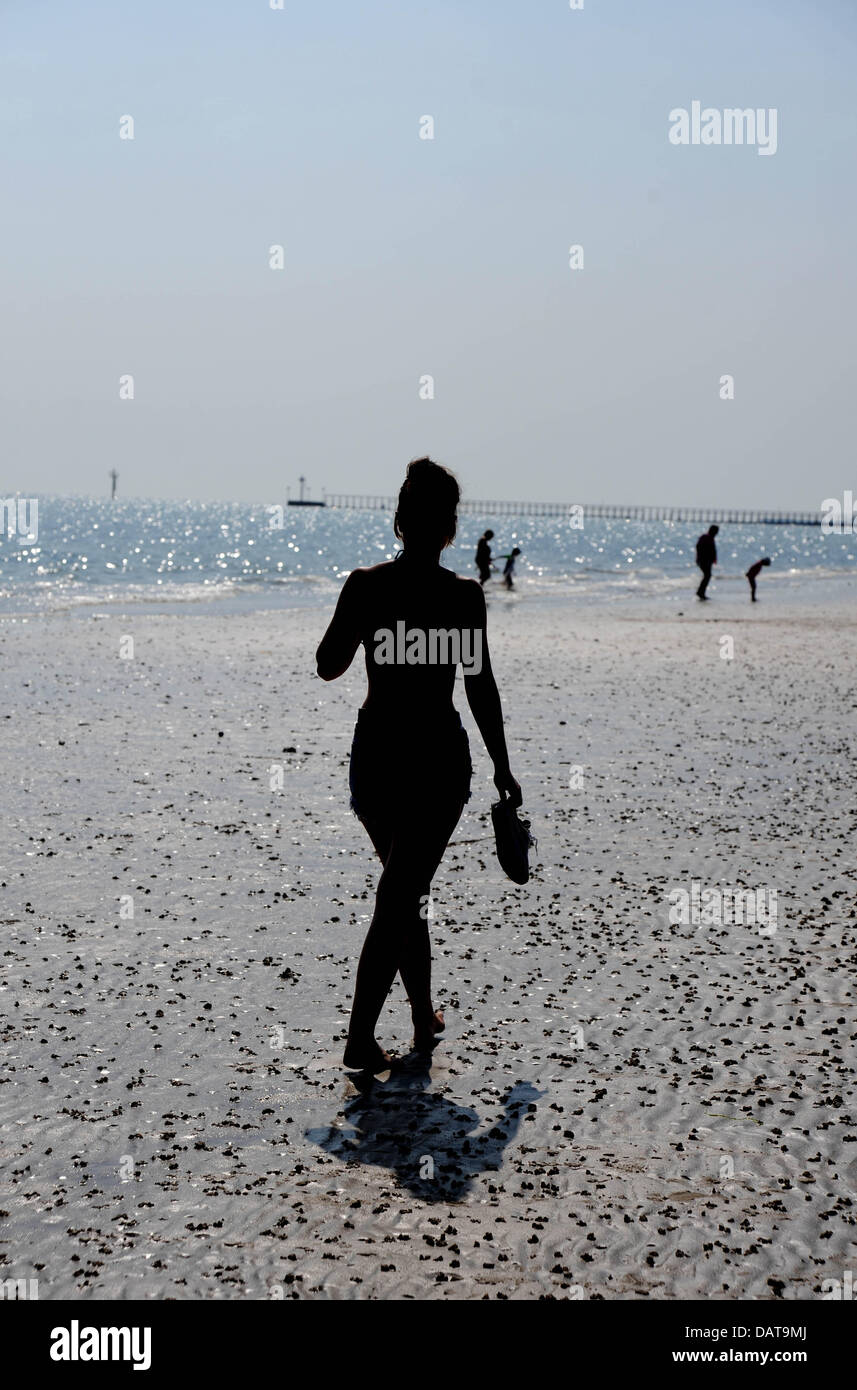 Littlehampton UK - Una giovane donna gode di una passeggiata lungo la spiaggia di Littlehampton sotto il sole del tardo pomeriggio mentre l'onda di calore continua in Gran Bretagna oggi fotografia scattata da Simon Dack/Alamy Live News Foto Stock