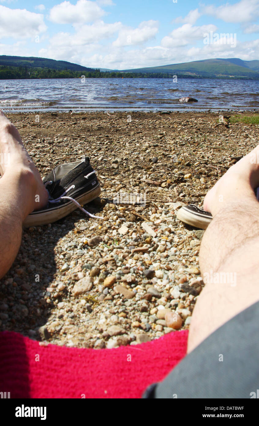 Loch Lomond Scozia 18 luglio 2013. L'uomo rilassante di sole sulle rive di Loch Credito: ALAN OLIVER/Alamy Live News Foto Stock