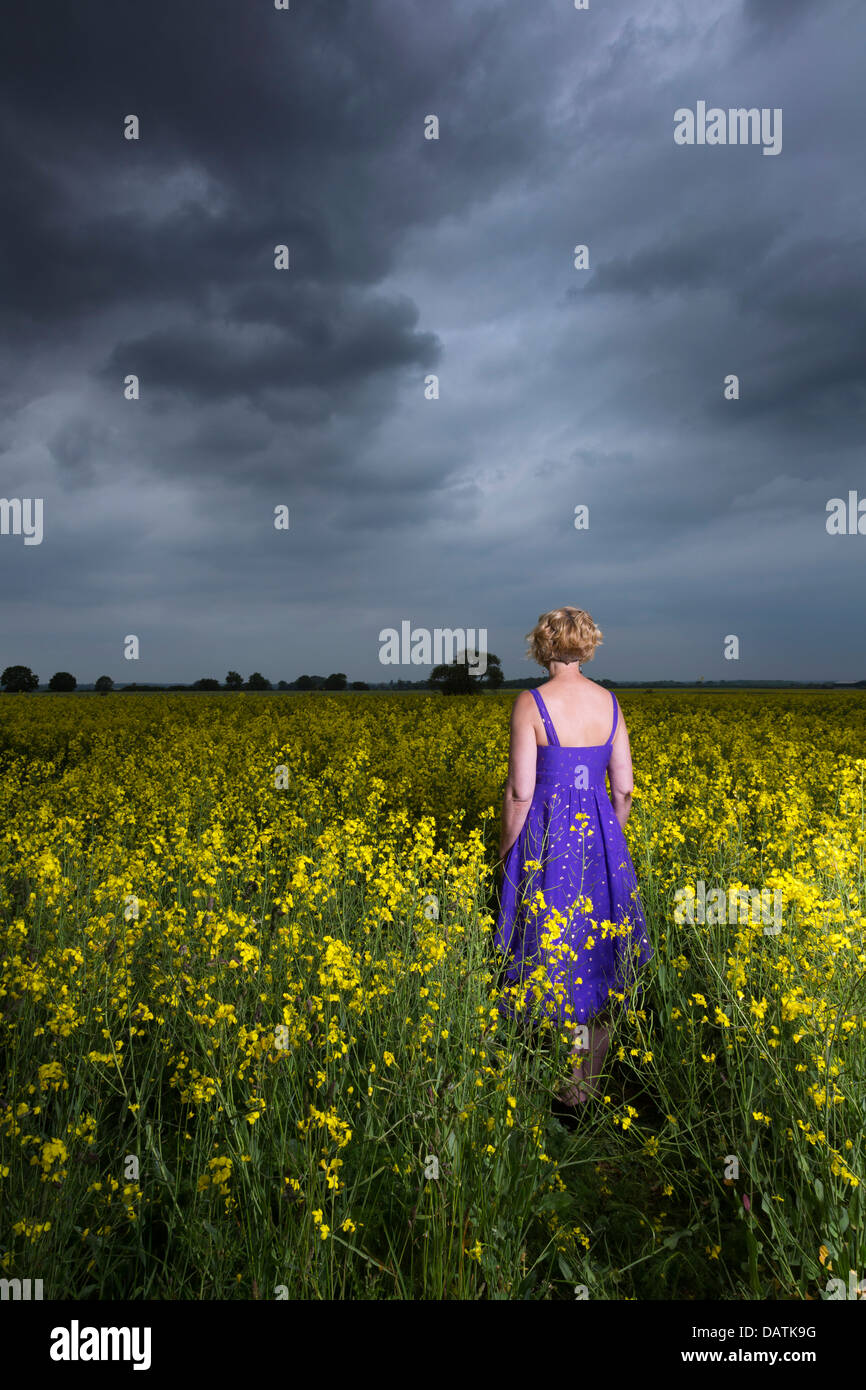Donna in piedi nel campo in aperta campagna Foto Stock