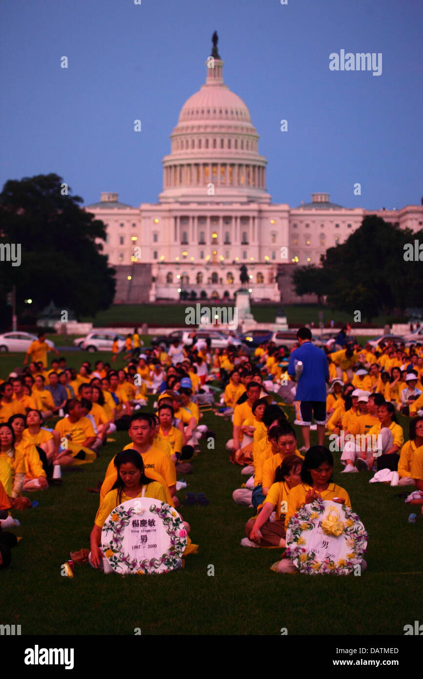 Washington DC, Stati Uniti d'America. 18 Luglio, 2013. Il Falun Gong membri commemorare il XIV anniversario del governo cinese la repressione contro di loro che è iniziato il XX luglio 1999. Alcune persone stanno tenendo i tributi con i nomi di coloro che sono stati uccisi durante la persecuzione. In fondo è la United States Capitol Building. Credito: James Brunker / Alamy Live News Foto Stock