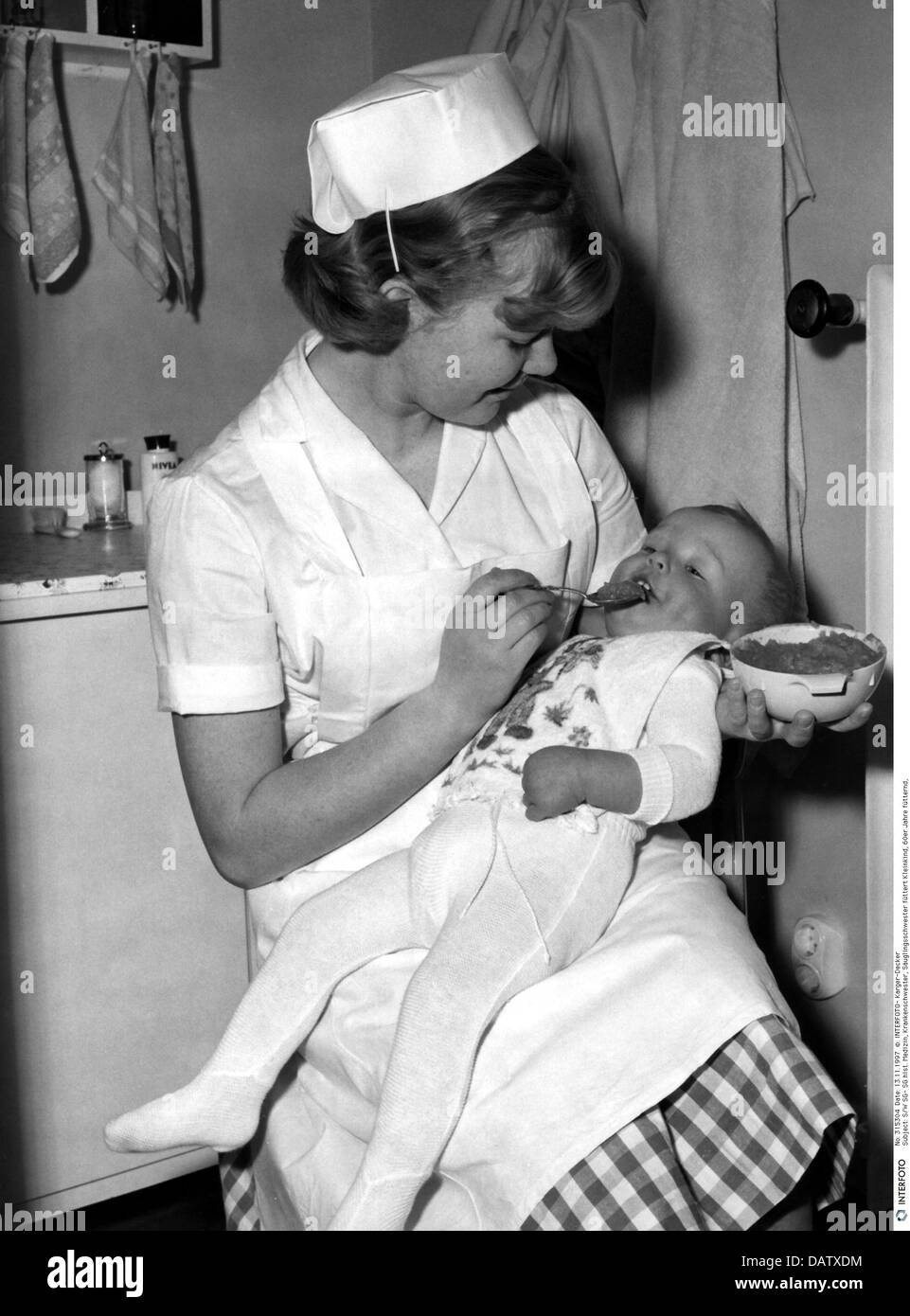 Medicina, infermiera, infermiera che allatta il bambino, 60s, diritti-aggiuntivi-clearences-non disponibile Foto Stock