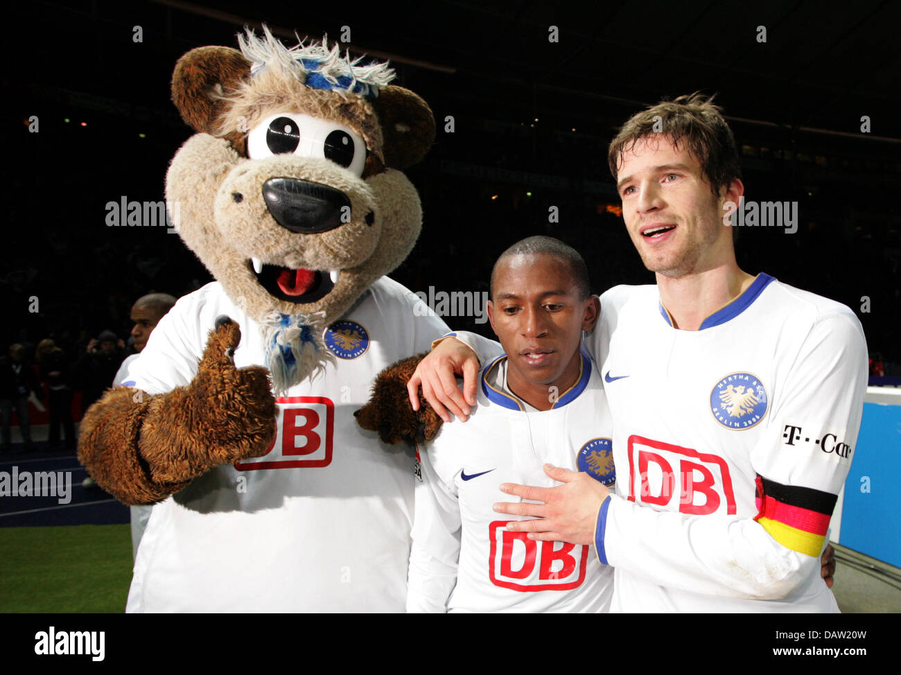 Vincitore della partita Mineiro (C) di Berlino cheers vincere il confronto con il compagno di squadra di Arne FRIEDRICH (R) e la squadra mascotte (L) dopo la partita della Bundesliga Hertha BSC Berlin vs SV Hamburg presso lo stadio olimpico di Berlino, Germania, 03 febbraio 2007. Berlin defetas Amburgo 2-1 con un ultimo minuto obiettivo. Foto: Johannes Eisele Foto Stock