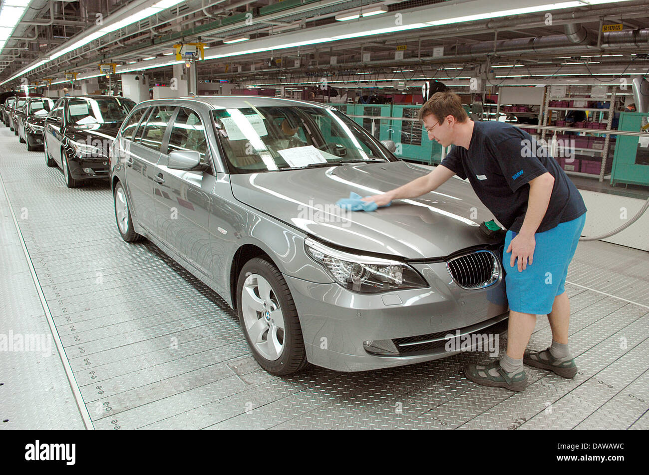 Un dipendente della casa costruttrice tedesca BMW leviga il cofano motore di una BMW Serie 5 di medie dimensioni per auto di lusso presso lo stabilimento di Dingolfing, Germania, Mercoledì, 14 marzo 2007. Foto: Armin Weigel Foto Stock