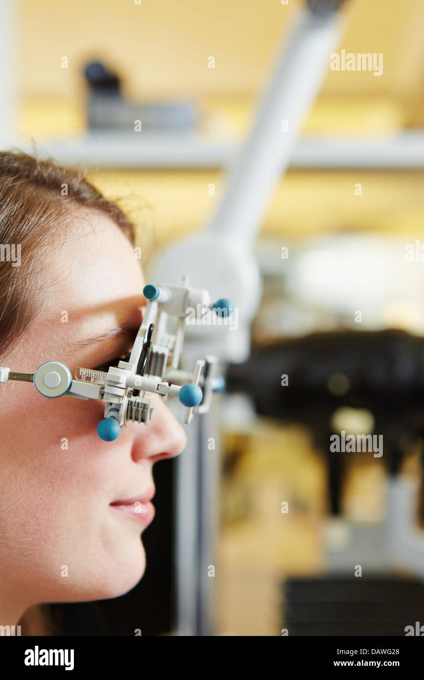 Giovane donna con telaio di prova per la determinazione della lente a ottico Foto Stock