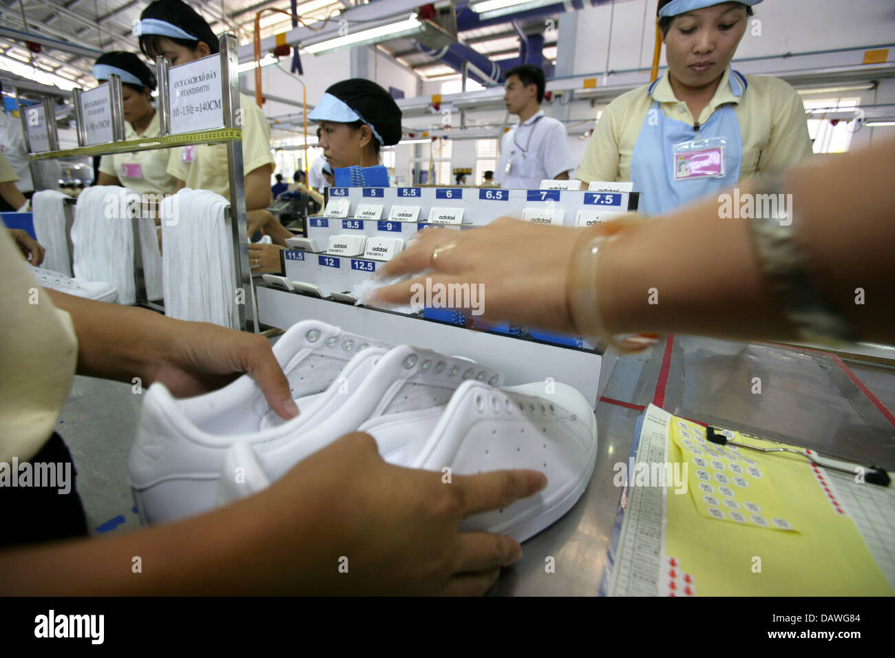 I lavoratori di sesso femminile di produrre dei formatori presso un impianto di Adidas in Ho Chi Minh City Vietnam 29 marzo 007. Foto Peter Kneffel Foto stock Alamy