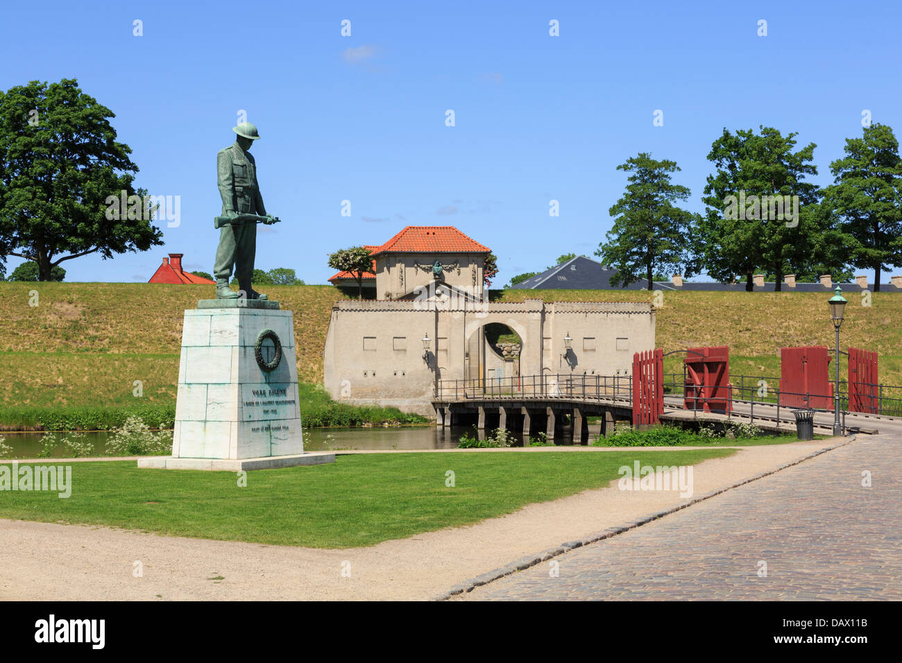 War Memorial statua di un soldato da ponte attraverso il fossato interno alla porta del re entrata a Kastellet fortificato di Copenhagen, Danimarca Foto Stock
