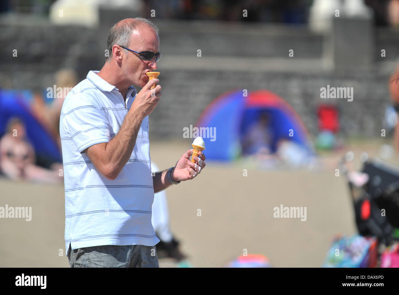 BARRY island, Regno Unito. Il 19 luglio 2013. Il British ondata di caldo continua e persone affollano le spiagge in Galles del Sud. Un uomo utilizza il tempo come una scusa per avere due coni gelato. Foto di Credito Credito: Polly Thomas / Alamy Live News Foto Stock