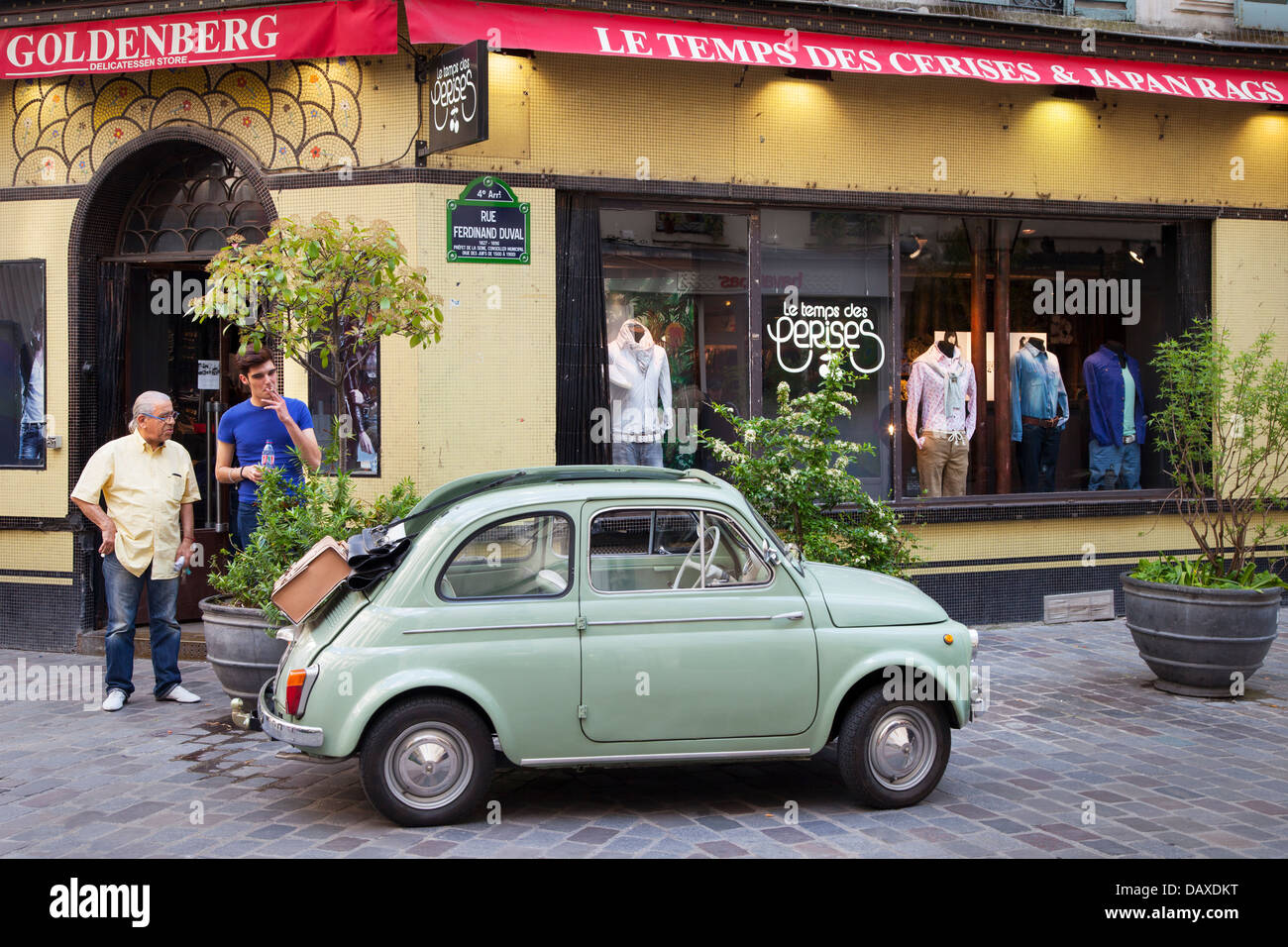 Due uomini ammirare un verde fiat parcheggiato nel quartiere di Marais, Parigi Francia Foto Stock