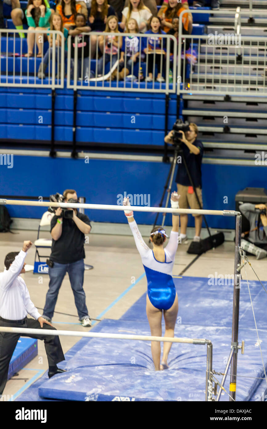 Donna compete per UF su superfici irregolari barre parallele durante Alabama Crimson Tide versus UF Gators donna ginnastica soddisfare (2-8-13). Foto Stock