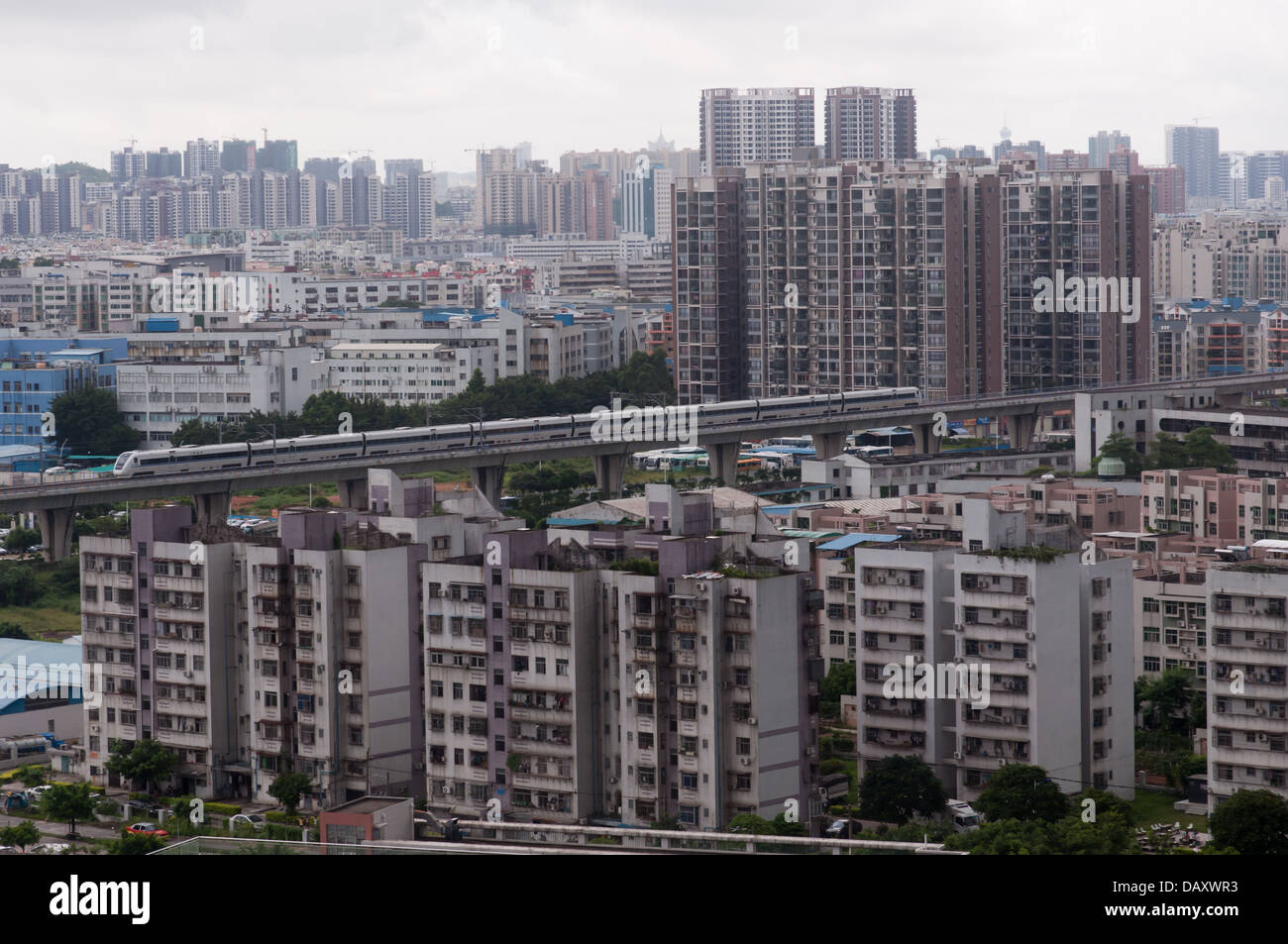 Un CRH treno veloce da Zhuhai a Guangzhou è visto su un ponte al di sopra della città. Foto Stock