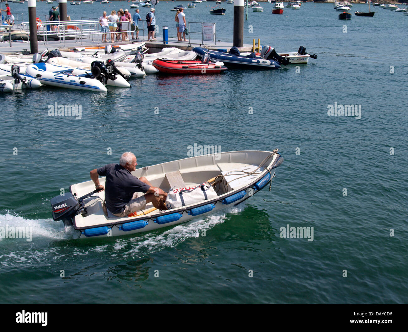 Il vecchio uomo in piccola barca con motore fuoribordo, Salcombe, Devon, Regno Unito 2013 Foto Stock
