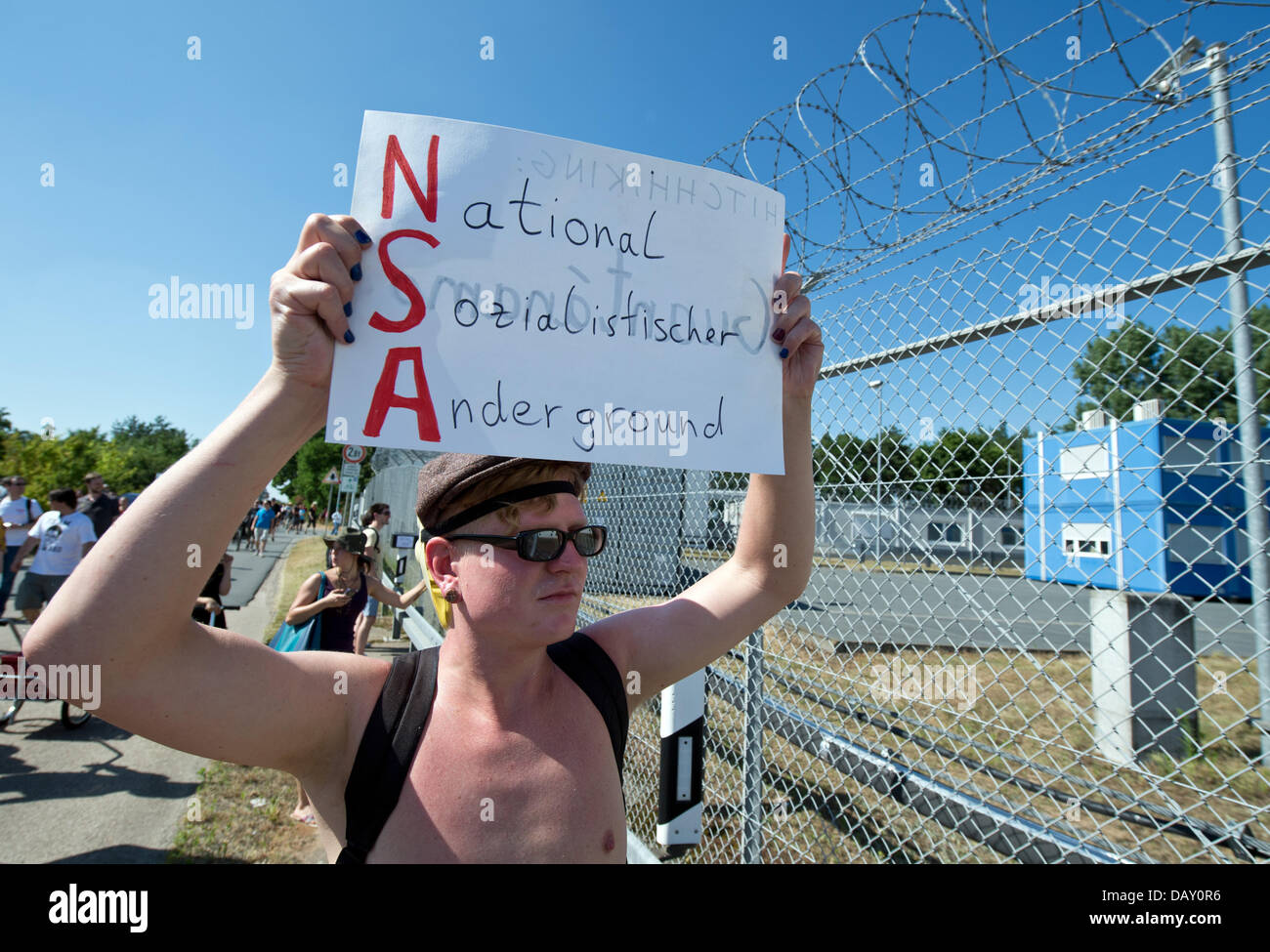 Berlino, Germania. Il 20 luglio, 2013. A poche centinaia di persone prendono parte a una protesta al di fuori di un US National Security Agency (NSA) stazione di ascolto in Griesheim vicino a Darmstadt, Germania, 20 luglio 2013. Come parte del "Picknick' azione, participents assemblato al di fuori dell'strettamente limitata US Army 'Dagger complessa" bloccando temporaneamente la strada. Foto: BORIS ROESSLER/dpa/Alamy Live News Credito: dpa picture alliance/Alamy Live News Foto Stock