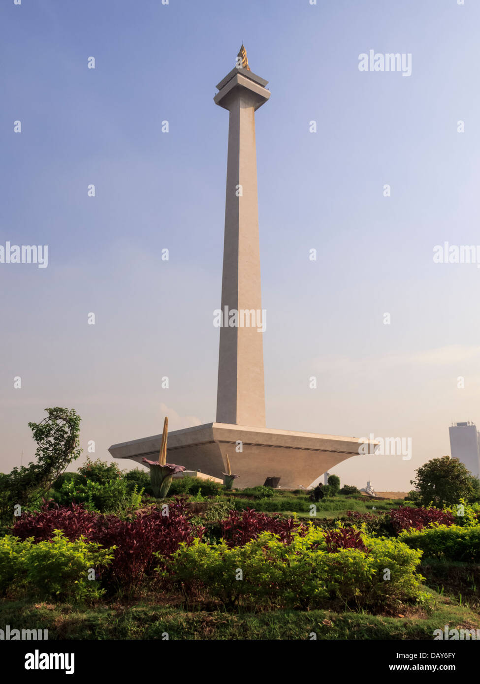 Jakarta, Java, Indonesia: piazza Merdeka Vista del Monumento Nazionale rising alta in un cielo blu circondato da un lussureggiante giardino Foto Stock