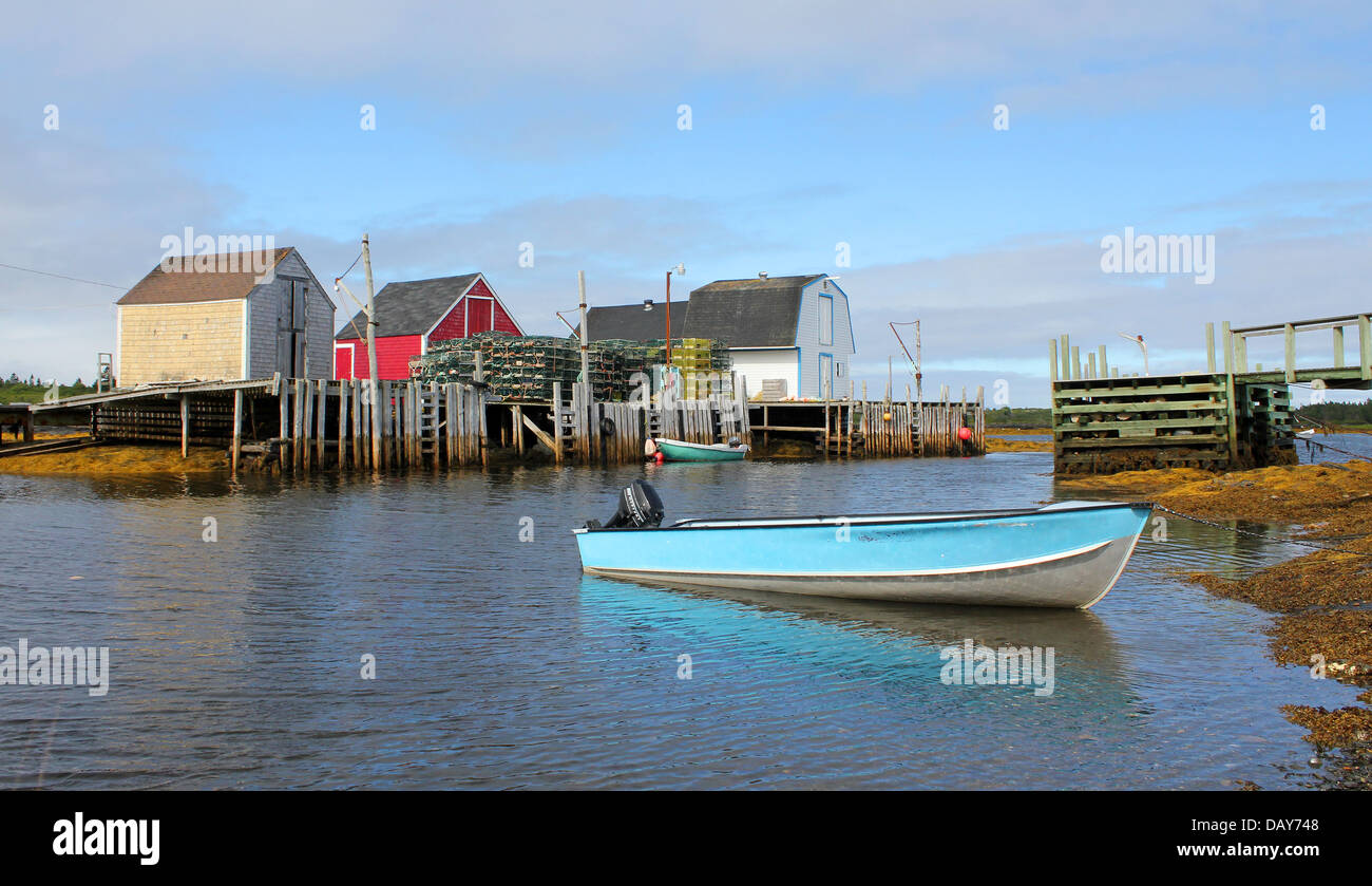 Paesaggio di colorate barche da pesca e baracche di aragosta e trappole in una tranquilla insenatura, blu rocce, Nova Scotia Foto Stock