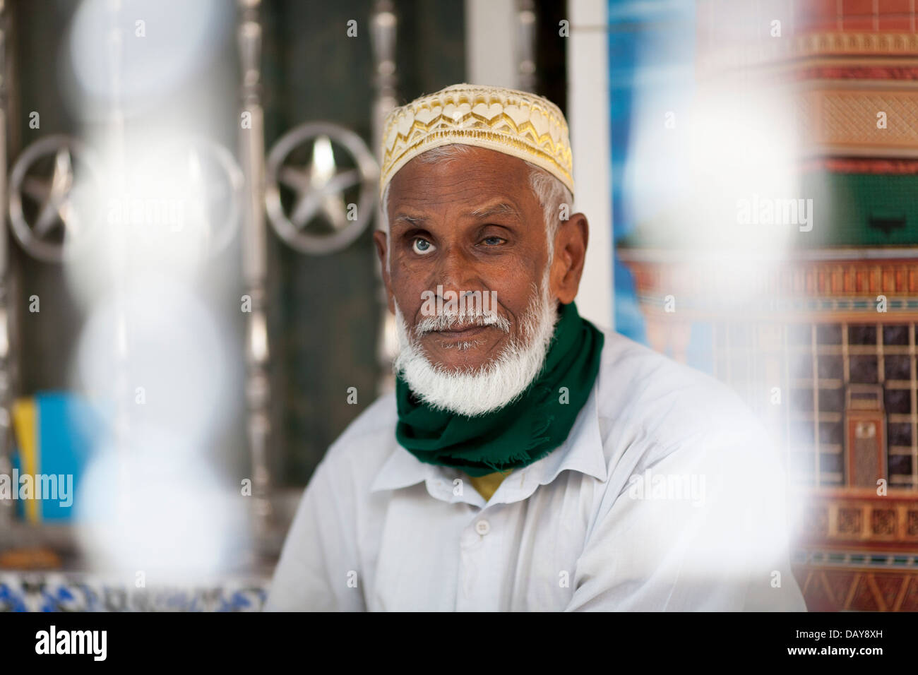 Un uomo musulmano con un occhio di vetro si trova all'interno di una moschea nella città vecchia di Dahak Bangladesh Foto Stock