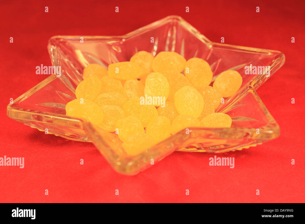 Gocce di limone in una caramella piatto su uno sfondo rosso Foto Stock