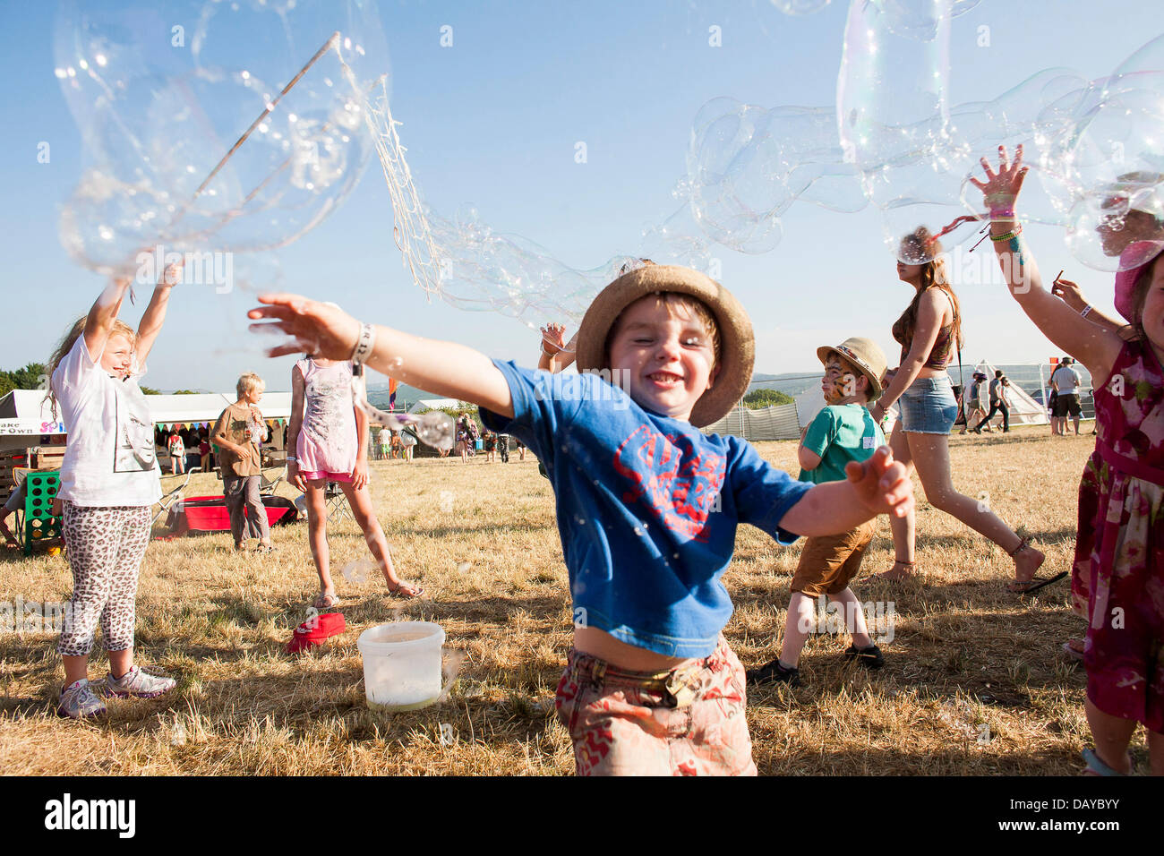 Oakhampton, UK. Il 20 luglio, 2013. Bambini chase bolle a Chagstock, un piccolo festival di musica vicino a Okehampton, Devon. Il tutto esaurito caso visto i frequentatori del festival godendo il caldo clima soleggiato che ha basked regno unito di recente. Il Met Office ha retrocesso l'ondata di caldo livello di avvertimento ma le temperature dovrebbero salire nuovamente durante la prossima settimana. 20 luglio 2013 Credit: Adam Gasson/Alamy Live News Foto Stock