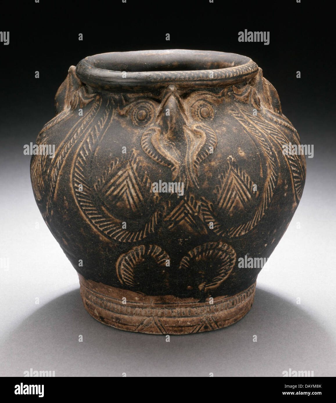 Questo barattolo presenta quattro gufi scolpite nel suo design, un simbolo di saggezza e conoscenza. Realizzato in ceramica, è un bell'esempio di artigianato antico, che mostra l'abilità e l'uso simbolico degli animali nelle ceramiche decorative. Tali pezzi sono stati utilizzati in vari contesti domestici e cerimoniali. Foto Stock