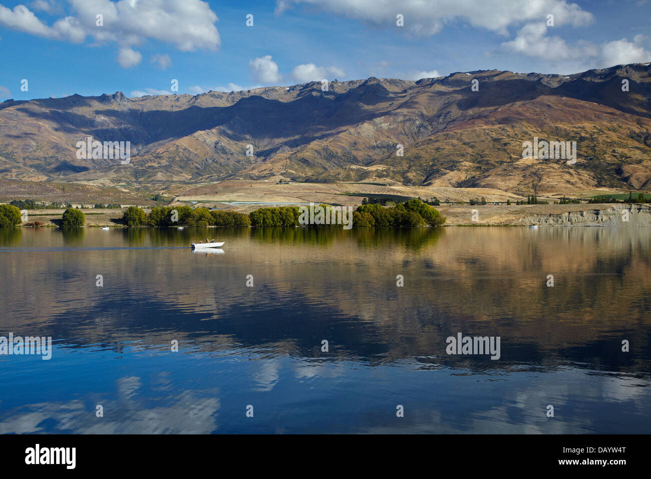 Il lago di Dunstan, Pisa di gamma e di persone in barca da pesca di Central Otago, Isola del Sud, Nuova Zelanda Foto Stock