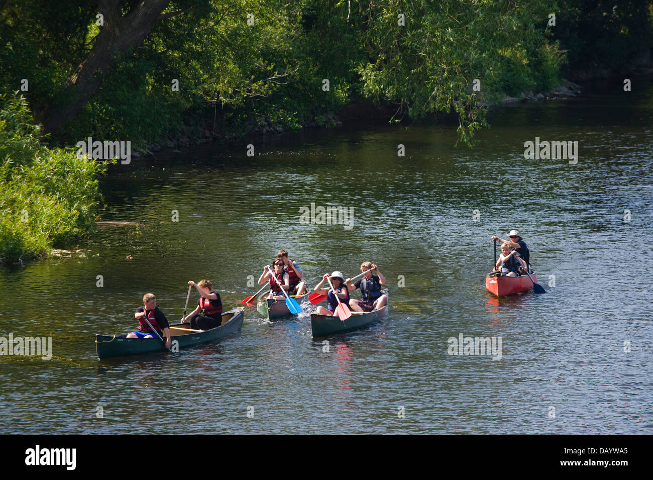 Bambini e adulti canoisti in open canoe kayak giù il fiume Wye a Glasbury Powys Wales UK Foto Stock