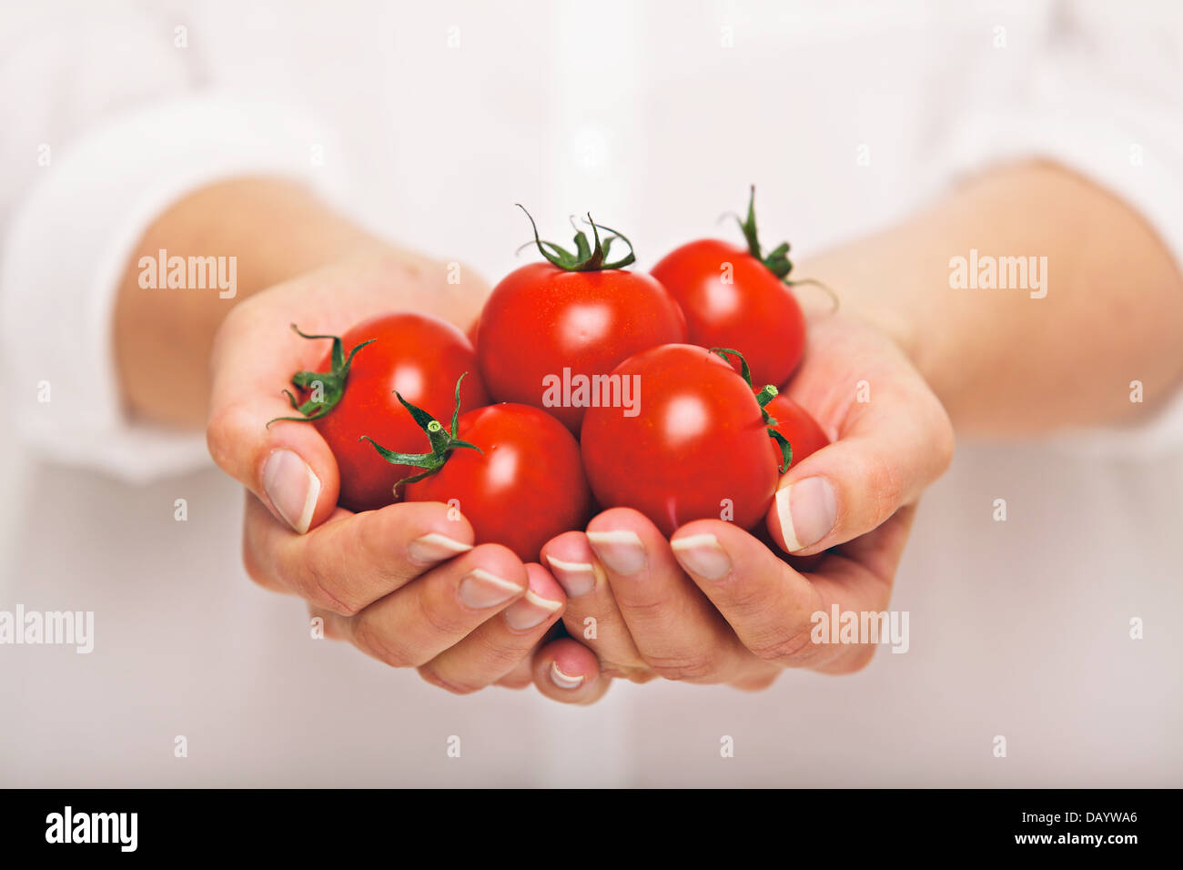 Femmina con una manciata di pomodori freschi Foto Stock