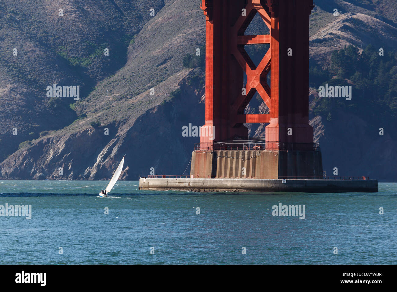 Piccola barca a vela alla base del Golden Gate Bridge Foto Stock