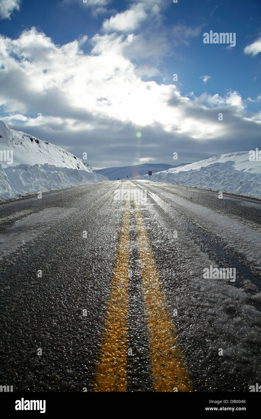 Sunstrike e strada ghiacciata su 'Pigroot' (autostrada statale 85) in inverno, Otago, Isola del Sud, Nuova Zelanda Foto Stock