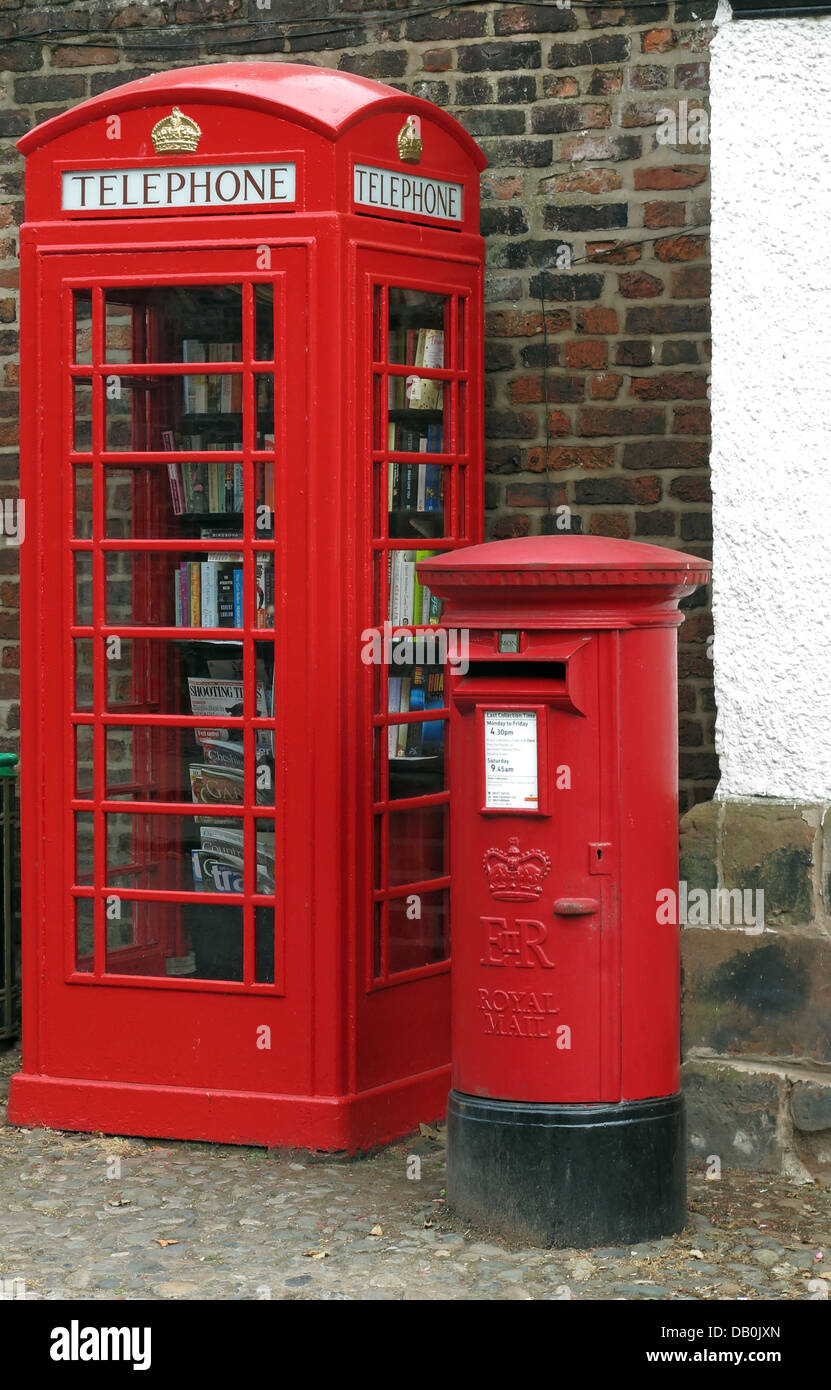 Un vecchio red britannico telefonica si è trasformato in un villaggio inglese eccentrico lending library , accanto a un posto di lavoro / scatola del montante Foto Stock