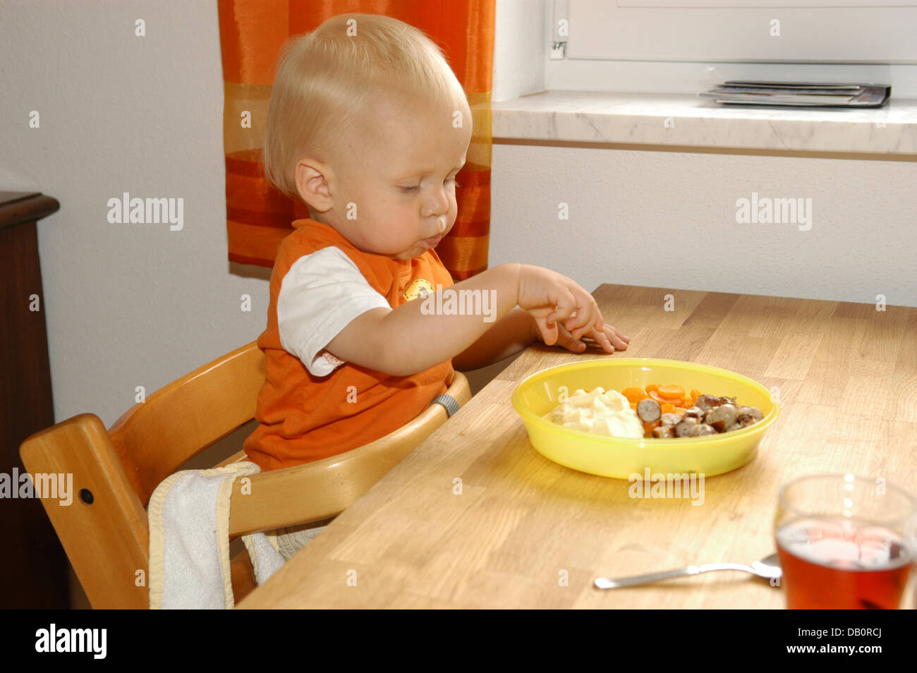 Lukas, figlio di Peter und Veronika Ott (non mostrato) si siede nel suo seggiolone come egli mangia il suo pranzo a casa dei genitori in Fuerstenfeldbruck, Germania, 28 luglio 2007. Peter Ott, che lavora a tempo pieno, e sua moglie Veronika, chi rimane a casa con i figli, godere della loro vita di famiglia con i loro due bambini Annika e Lukas. Foto: Felix Hoerhager Foto Stock