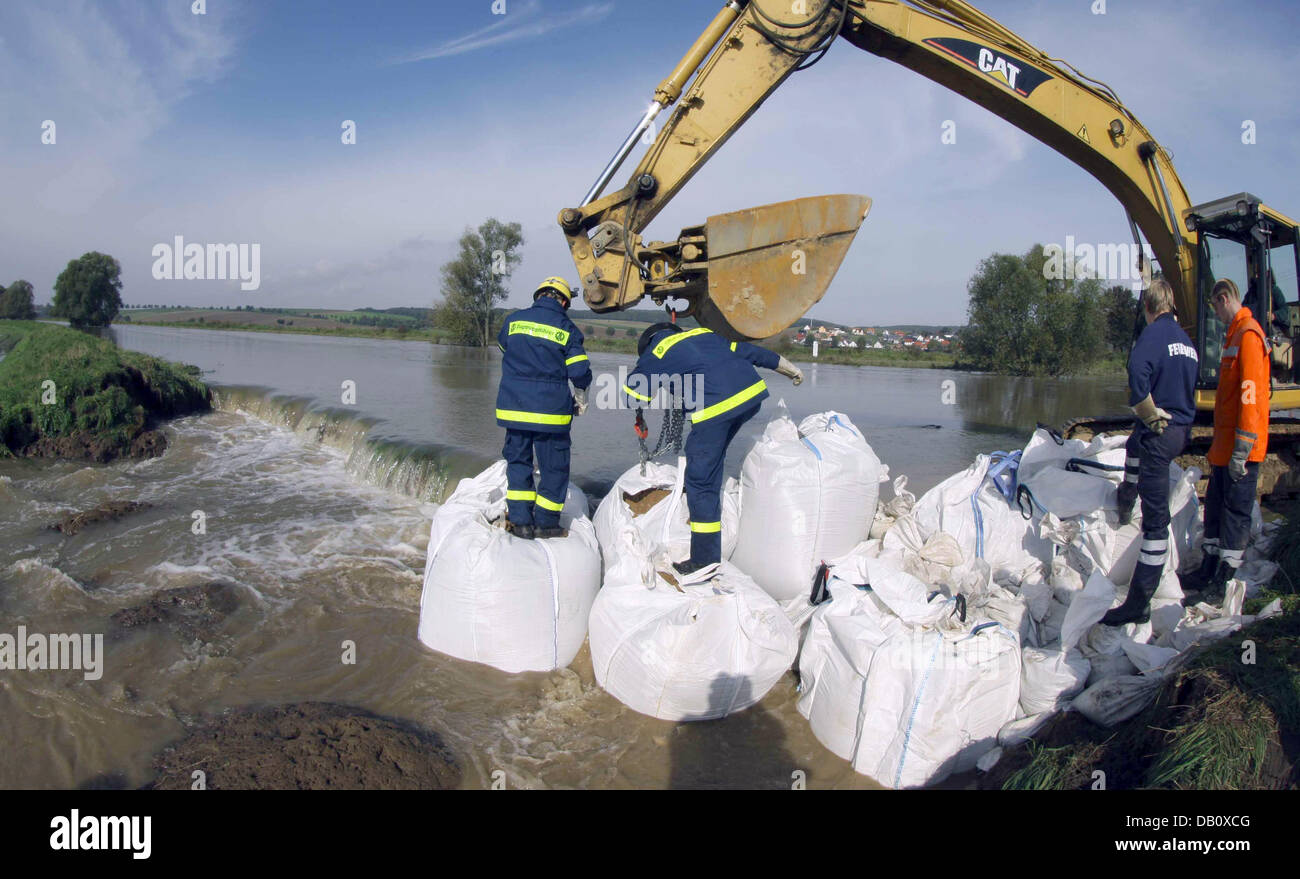 I vigili del fuoco e unità di sfiato dell'Agenzia federale tedesca per il sollievo pila di sacchi di sabbia dopo una violazione di un argine dal fiume Innerste vicino Heersum, Germania. Nonostante molte violazioni della diga per la prima volta la situazione sembra migliorare nel diluvio zone della Bassa Sassonia. È possibile che il red alert delcared nel distretto di Hildesheim dopo le forti inondazioni sul weekend cou Foto Stock