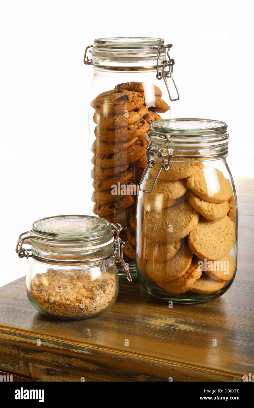 Il cioccolato e i cookie di lavanda e frantumato le nocciole in un vaso sul tavolo rustico e sfondo bianco Foto Stock