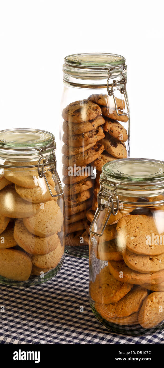 Cioccolato, lavanda e nocciola i cookie in un vaso sul tavolo rustico con blu scuro gingham tovaglia e sfondo bianco Foto Stock