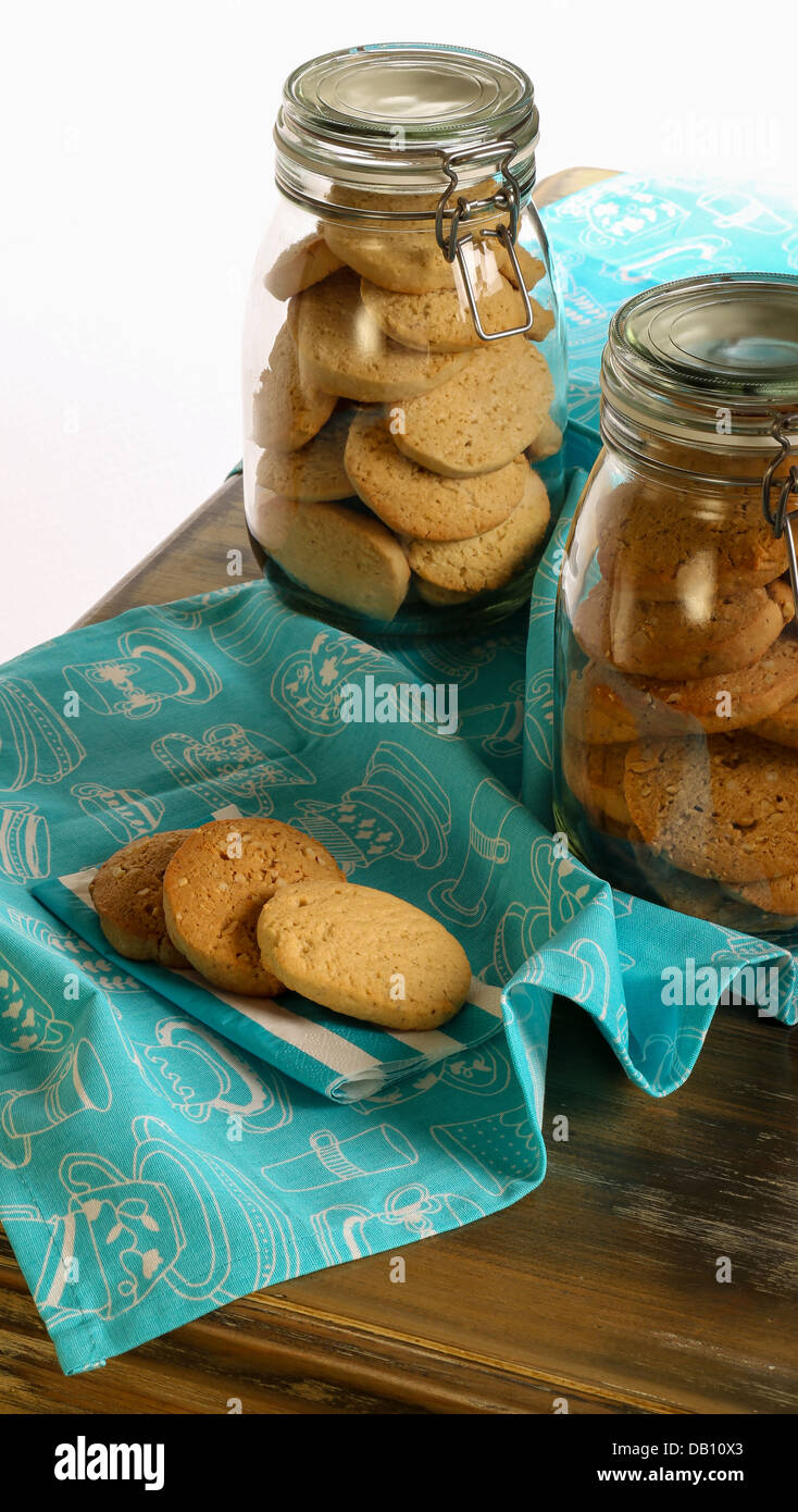Lavanda e nocciola cookies sulla Tovaglia e tovagliolo e in vaso sul tavolo rustico con tovaglia turchese e sfondo bianco Foto Stock