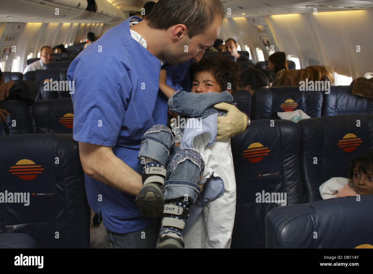 Un medico porta un ferito ragazza afgana durante il volo in direzione di Amburgo (Germania) da Kabul, 17 ottobre 2007. 59 gravemente i bambini feriti dall' Afghanistan era volato in Germania per essere curati in 30 cliniche su tutto il territorio nazionale. Si tratta di uno dei più grandi airlifts umanitaria della storia recente dell'Europa, organizzata dall'iniziativa "i bambini hanno bisogno di noi' e. V. e di Amburgo Albertinen-Grou Foto Stock