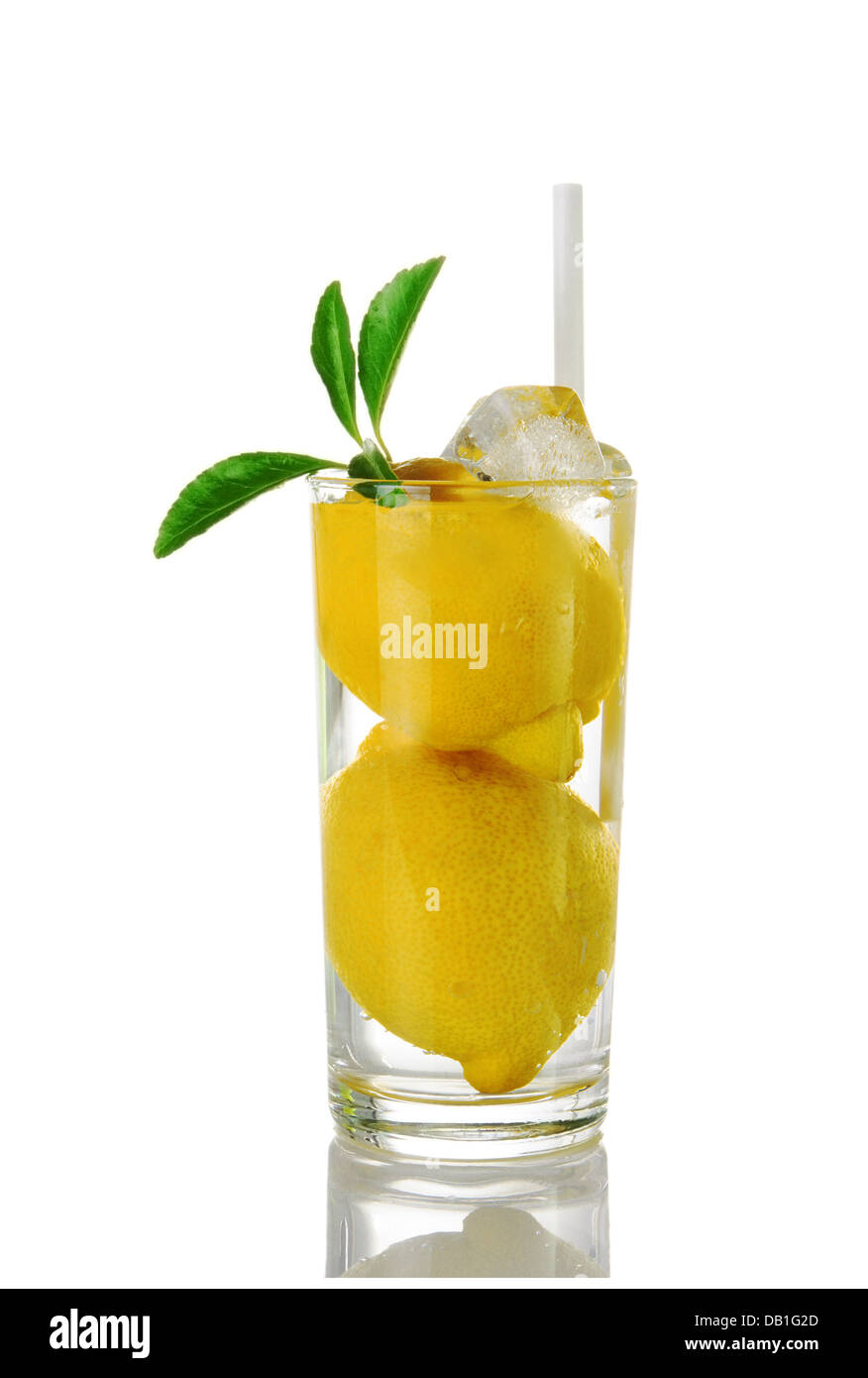 Bicchiere di acqua con i limoni interi su sfondo bianco Foto Stock