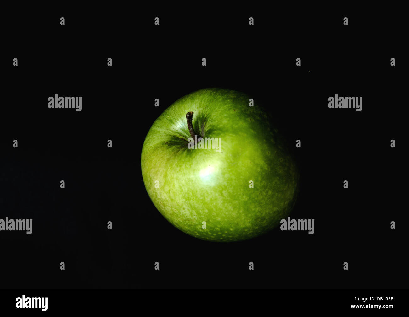 Verde mela isolare in sfondo nero Foto Stock