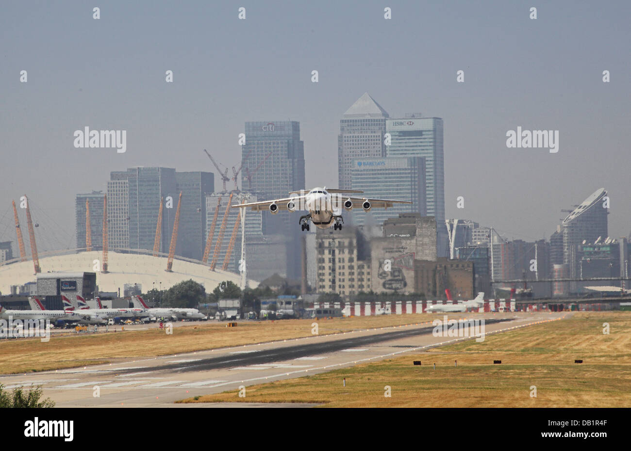 Un British Aerospace 146 decolla dall'Aeroporto di London City con Canary Wharf e il Millennium Dome in background Foto Stock